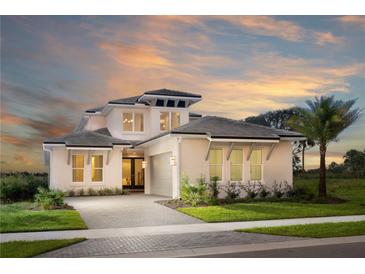 Stunning two-story home featuring a paver driveway, well-manicured lawn, and lush landscaping at 0000 Se 47Th Loop, Ocala, FL 34480