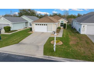 Charming single-story home with a well-manicured lawn and attached two-car garage at 1903 Nw 50Th Cir, Ocala, FL 34482