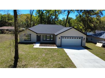 Charming single-story home featuring a two-car garage and a well-maintained front lawn at 6276 Nw 65 Nw Pl, Ocala, FL 34482