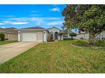 Charming home featuring a well-manicured lawn, a spacious driveway, and an attached two-car garage at 7178 Sw 113Th Loop, Ocala, FL 34476