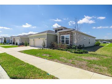 Landscaped single-Gathering home featuring a two-car garage at 7374 Sw 77Th Ave, Ocala, FL 34481
