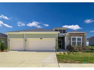 Charming single-Gathering home with a two-car garage, well-maintained lawn, and stone accents at 7374 Sw 77Th Ave, Ocala, FL 34481