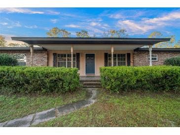 Charming single-story home with brick accents, a covered porch, and lush landscaping at 4040 E Fort King St, Ocala, FL 34470