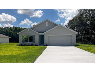 Charming single-story home with a well-manicured lawn and a two-car garage on a sunny day at 15313 Sw 59Th Ct, Ocala, FL 34473
