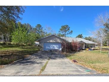 Charming single-story home featuring a large garage and spacious front yard on a sunny day at 22 Hemlock Ter, Ocala, FL 34472