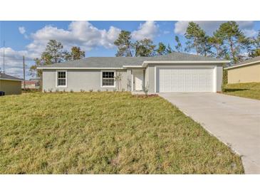 Charming single-story home with a well-manicured lawn and attached two-car garage at 476 Marion Oaks Pass, Ocala, FL 34473