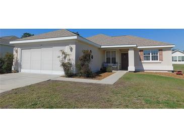 Charming single-story home with a well-maintained lawn and a two-car garage at 13100 Se 93Rd Terrace Rd, Summerfield, FL 34491