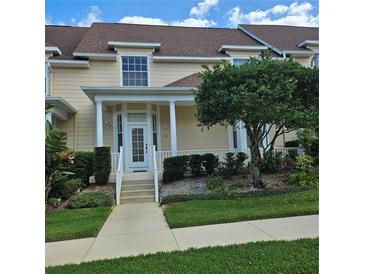 Charming townhome with a welcoming front porch, lush landscaping, and a well-maintained exterior at 162 Riggings Way, Clermont, FL 34711