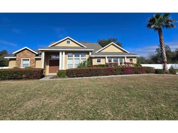 Inviting single-story home featuring well-manicured landscaping and a symmetrical facade against a bright blue sky at 3401 Se 49Th Ave, Ocala, FL 34480