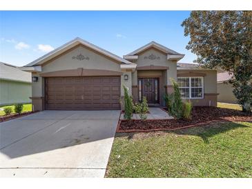 Charming single-story home with a well-maintained lawn and a two-car garage at 5464 Sw 41St St, Ocala, FL 34474