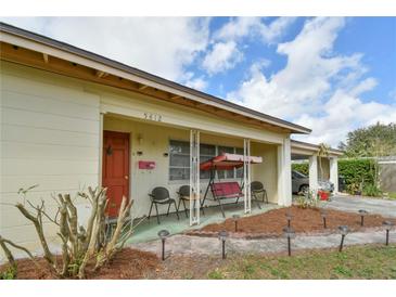 Charming front porch with porch swing, seating, and cozy landscaping featuring a brick-lined walkway with in-ground lighting at 5812 Luzon Pl, Orlando, FL 32839