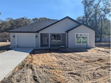 Charming single-story home with a well-manicured lawn, attached garage, and inviting front porch at 6254 Nw 65Th Nw Pl, Ocala, FL 34482