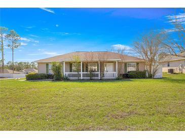 Charming single-story home featuring a large front yard and a cozy porch perfect for relaxing at 7398 Hemlock Rd, Ocala, FL 34472