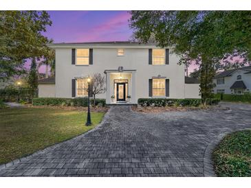 Stately two-story home with lush landscaping and paver driveway at 905 Se 12Th St, Ocala, FL 34471