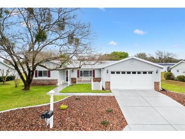 Charming single-story home with a well-manicured lawn and a two-car garage at 9493 Se 173Rd Ln, Summerfield, FL 34491