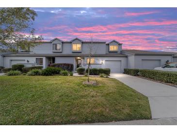 Charming townhome featuring a well-manicured lawn and beautiful landscaping, with an attached garage and updated facade at 1947 Se 37Th Court Cir, Ocala, FL 34471