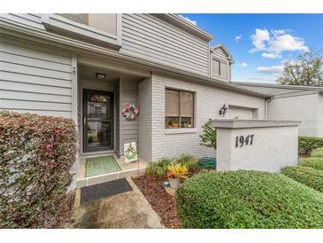 Charming front entrance of a townhouse featuring a decorative wreath and well-manicured landscaping at 1947 Se 37Th Court Cir, Ocala, FL 34471