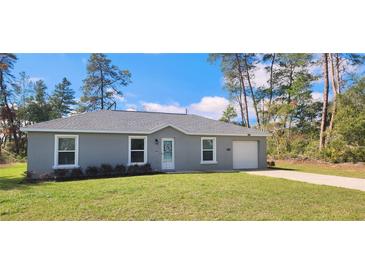 Charming single-story home with a gray exterior, well-manicured lawn, and an attached one car garage at 3326 Sw 128Th Street Rd, Ocala, FL 34473