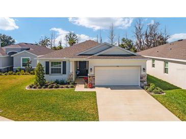 Charming single-story home featuring a well-manicured lawn, a two-car garage, and stone accents for added curb appeal at 5370 Sw 45Th Ave, Ocala, FL 34474