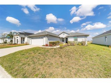 Charming single-story home featuring a well-manicured lawn and attached two-car garage on a sunny day at 6213 Sw 97Th St, Ocala, FL 34476