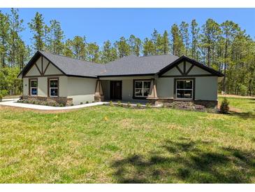 Charming single-story home featuring stone accents, timber details, and a well-manicured lawn in a wooded setting at 8303 Sw 127 Ave, Dunnellon, FL 34432