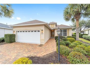 Charming single-story home with a well-manicured lawn, brick driveway, and a two-car garage at 8669 Sw 88Th Loop, Ocala, FL 34481