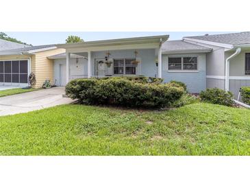 Charming single-story home with a well-maintained lawn and lush landscaping at 8677 Sw 95Th Ln # E, Ocala, FL 34481