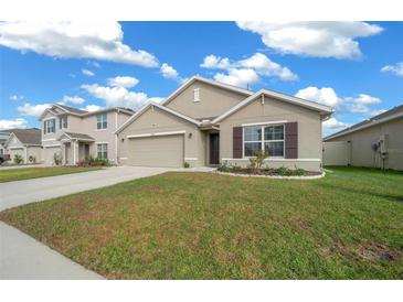 Charming single Gathering home featuring a well-manicured front yard, neutral toned stucco, and a two car garage at 8920 Sw 49Th Cir, Ocala, FL 34476