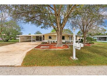 Charming single-story home features a large, shaded front yard, a covered carport and a welcoming front porch at 8973 Sw 104Th Pl, Ocala, FL 34481