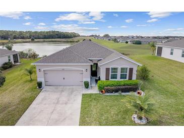 Charming single-story home with a well-manicured lawn and two-car garage, nestled by a scenic lake at 9238 Sw 60Th Terrace Rd, Ocala, FL 34476