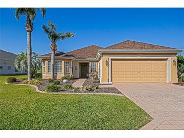 Charming single-story home featuring a manicured lawn and a two-car garage at 13128 Se 97Th Terrace Rd, Summerfield, FL 34491