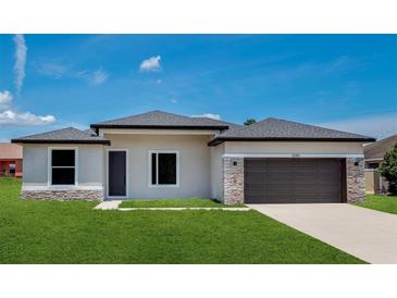 Charming single-story home featuring a stone accent and two-car garage door, plus freshly cut lawn at 2602 Sw 154Th Ln, Ocala, FL 34473