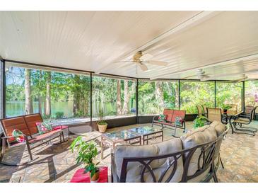 A spacious screened-in patio with comfortable seating provides stunning views of the lake at 11720 Cherokee Cir, Dunnellon, FL 34431