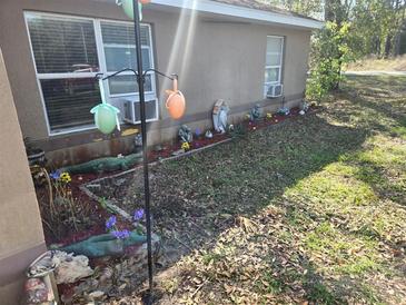 Modest, one-story home with a brown exterior and simple landscaping at 11860 Nw 18Th Pl, Ocala, FL 34482