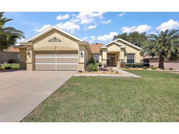 Charming single-story home with a well-manicured lawn, desert landscaping, and an attached two-car garage at 12133 Se 91St Ter, Summerfield, FL 34491