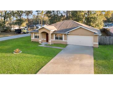 Charming one-story home with a well-manicured lawn and an attached two-car garage at 5758 Nw 63Rd Pl, Ocala, FL 34482
