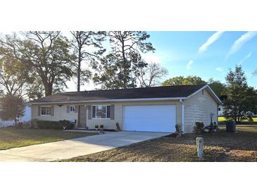 Charming single-story home with a well-maintained lawn and a two-car garage and mature landscaping at 8516 Sw 105Th Pl, Ocala, FL 34481