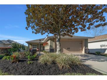 Charming home featuring a well-manicured yard, neutral-toned exterior, and an attached two-car garage at 9463 Sw 93Rd Loop, Ocala, FL 34481