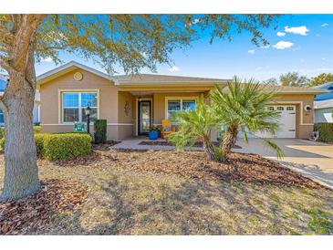 Charming single-story home featuring a well-manicured front yard with mature trees and landscaping at 9841 Sw 95Th Loop, Ocala, FL 34481