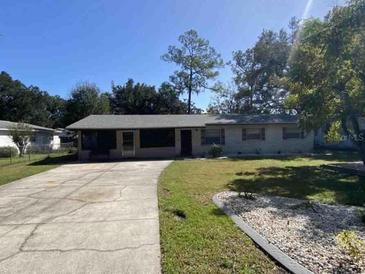 Charming single-story home with a well-maintained front lawn and long driveway at 1127 Enchanted Dr, Lakeland, FL 33801