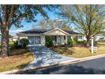 Charming single-story home featuring mature trees, a well-manicured lawn, and a spacious driveway at 11721 Sw 137Th Loop, Dunnellon, FL 34432