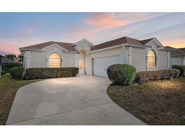 Charming single-story home with a well-manicured lawn, arched windows, and a spacious driveway at 5891 Nw 26Th St, Ocala, FL 34482