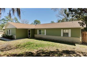 Charming single-story home features a brick foundation and verdant lawn under a clear, sunny sky at 10370 Sw 110Th St, Dunnellon, FL 34432