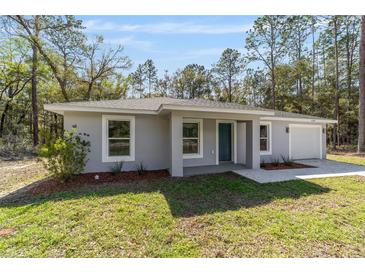 Beautiful single-story home with modern paint, landscaped yard, and one car garage at 13396 Sw 105 Pl, Dunnellon, FL 34432