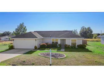 Charming single-story home featuring a well-maintained lawn and an attached two-car garage at 14 Juniper Drive Crse, Ocala, FL 34480