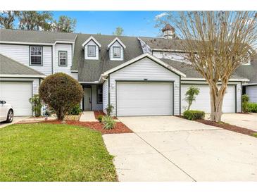 Charming townhome with a two-car garage, manicured lawn, and beautiful landscaping at 231 Ne 28Th Ave # 103, Ocala, FL 34470