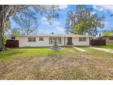 Charming single-story home with a well-maintained front yard and fountain feature under a mature tree at 1818 Se Lake Weir Ave, Ocala, FL 34471