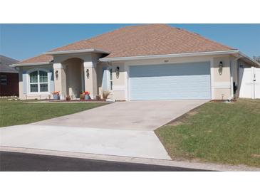 Inviting single-story home featuring an attached two-car garage, manicured lawn and a charming arched entryway at 3819 Se 99Th St, Belleview, FL 34420