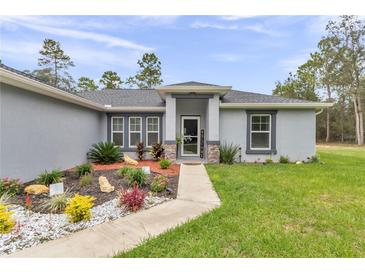 Charming home exterior with a well-manicured lawn, rock landscaping and a welcoming front entrance at 5620 Sw 172Nd Loop, Ocala, FL 34473