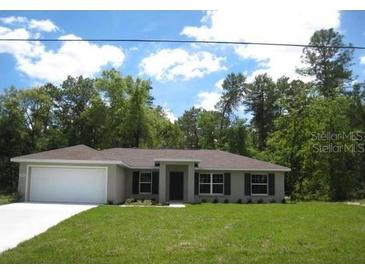 Charming single-story home with a well-maintained lawn and neutral-colored exterior at 12805 Sw 38Th Cir, Ocala, FL 34473